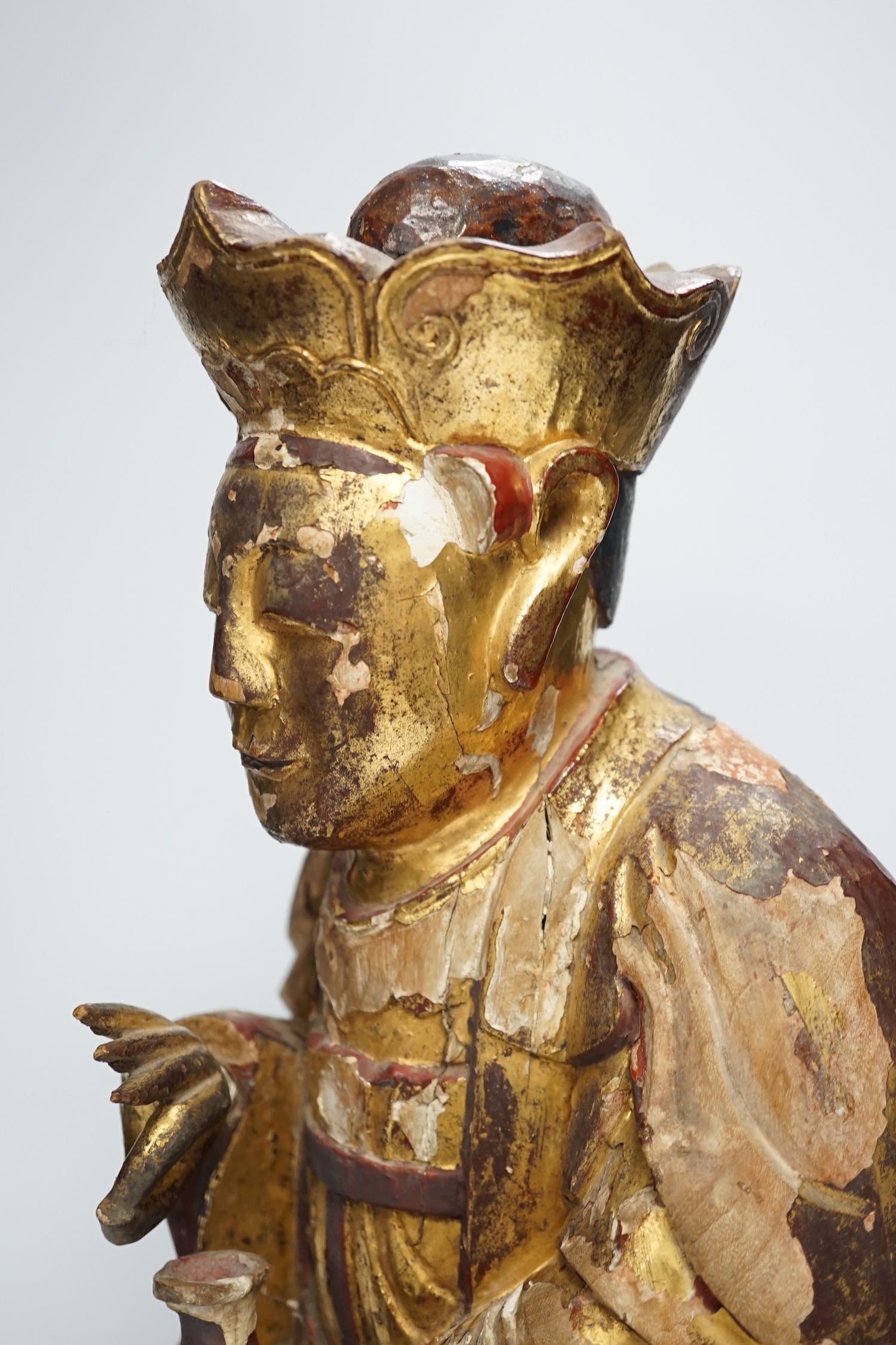 A Chinese gilt lacquered wooden figure of Buddha, possibly Yuan to Ming, 42cm high. Condition - poor to fair, losses to lacquer overall